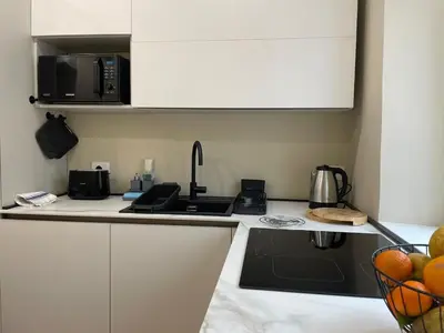 a kitchen with white cabinets and a sink and a bowl of fruit at SAINT PETER home and holiday apartment in Rome