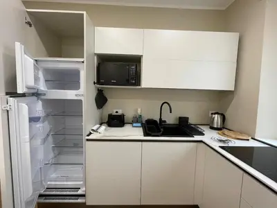 a kitchen with white cabinets and an open refrigerator at SAINT PETER home and holiday apartment in Rome