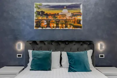 a white bedroom with a bed and a chair at Medaglie d'Oro Vaticano in Rome