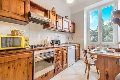 a kitchen with a wooden counter top and a table at Emanuele House by GHOR in Rome