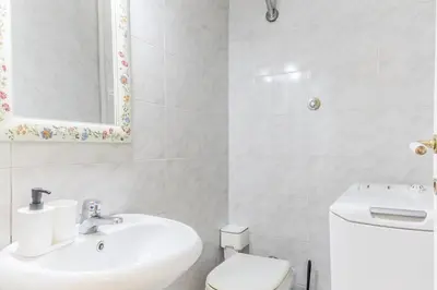a white bathroom with a sink and a toilet at Emanuele House by GHOR in Rome