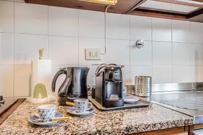 a kitchen counter with a coffee maker and two cups at Emanuele House by GHOR in Rome