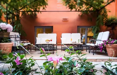 a group of white chairs and tables in a courtyard at Hotel Ponte Sisto in Rome