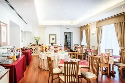 a dining room with tables and chairs with red tablecloths at Hotel Ponte Sisto in Rome