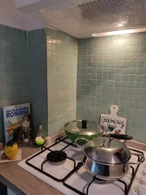 a kitchen stove with two pots and pans on it at Garbatella, lovely mini apartment in Rome