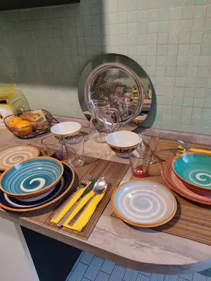 a table with plates and utensils on a counter at Garbatella, lovely mini apartment in Rome