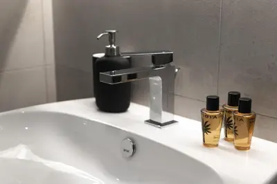 a bathroom sink with a faucet and two bottles at Rienzo Apartment near Vatican in Rome