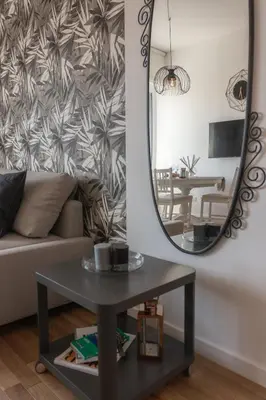 a living room with a table and a mirror at Rienzo Apartment near Vatican in Rome