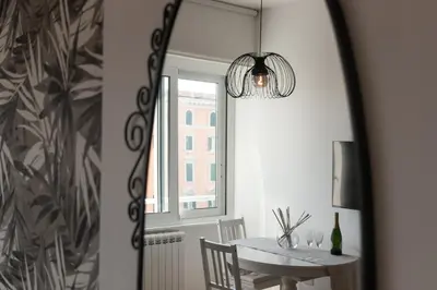 a dining room mirror with a table and a window at Rienzo Apartment near Vatican in Rome