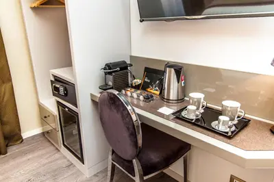 a small kitchen with a desk with a coffee maker at Calisto Luxury Trastevere in Rome