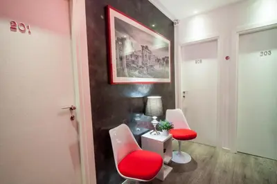 a room with two red chairs and a table at Calisto Luxury Trastevere in Rome