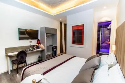 a bedroom with a bed and a desk with a chair at Calisto Luxury Trastevere in Rome