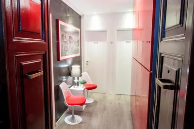 a room with two chairs and a table with a red chair at Calisto Luxury Trastevere in Rome