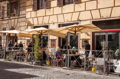 a group of people sitting at tables under umbrellas at Calisto Luxury Trastevere in Rome