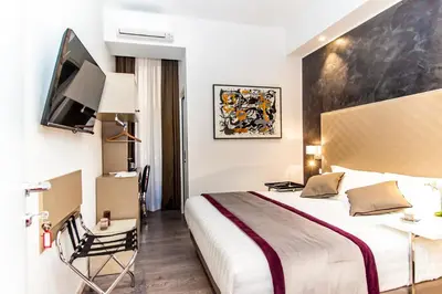 a hotel room with a bed and a tv at Calisto Luxury Trastevere in Rome