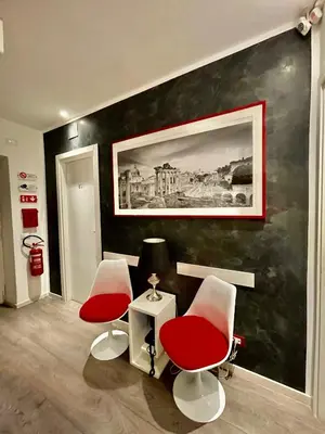 a room with two red chairs and a painting on a wall at Calisto Luxury Trastevere in Rome