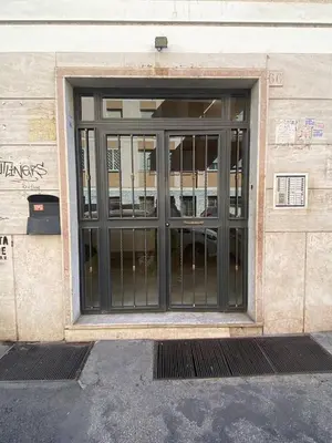 a glass door of a building with a sign on it at Armandino's sweet home Roma in Rome
