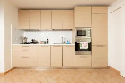 a large kitchen with wooden cabinets and appliances at Peaceful hidden gem near Metro A and Colosseum in Rome