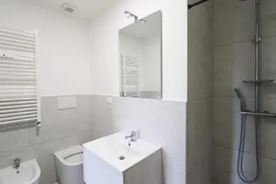 a white bathroom with a sink and a toilet at Modern Deluxe 2 Suites Apartment - 15min Colosseum & Metro 5min - AC, Wifi in Rome