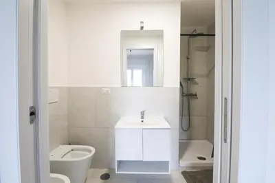 a white bathroom with a sink and a toilet at Modern Deluxe 2 Suites Apartment - 15min Colosseum & Metro 5min - AC, Wifi in Rome