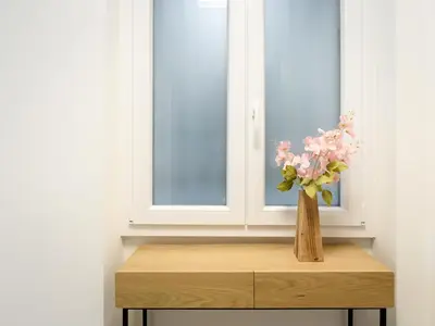 a vase of pink flowers sitting on a table next to a window at Domus suites in Rome