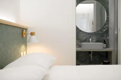 a bedroom with a white bed and a mirror at Domus suites in Rome