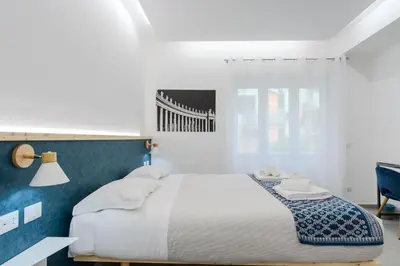 a bedroom with a large bed with a blue accent wall at Domus suites in Rome