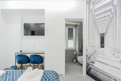 a bedroom with a bed and two blue chairs at Domus suites in Rome