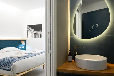a bathroom with a tub and a bed with a mirror at Domus suites in Rome