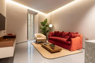a living room with a red couch and a table at Domus Suites Colosseum in Rome