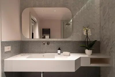 a bathroom with a white sink and a mirror at Domus Suites Colosseum in Rome