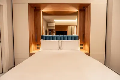 a bedroom with a white bed and a blue chair at Domus Suites Colosseum in Rome