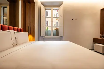a large white bed in a room with a window at Domus Suites Colosseum in Rome
