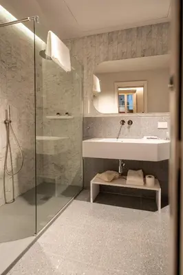 a bathroom with a sink and a mirror and a shower at Domus Suites Colosseum in Rome