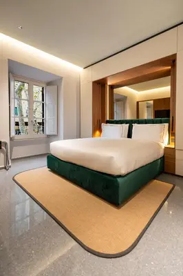 a bedroom with a large bed with a large mirror at Domus Suites Colosseum in Rome