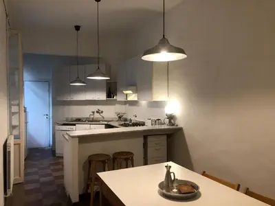 a kitchen with a table and three pendant lights at Boschetto Apartment in Rome