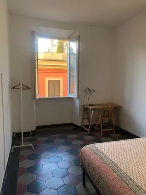 a room with a bed and a window and a table at Boschetto Apartment in Rome