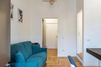 a living room with a blue couch at Bartolomeo de' Vaccinari - FromHometoRome in Rome