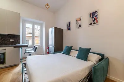 a bedroom with a large white bed with blue pillows at Bartolomeo de' Vaccinari - FromHometoRome in Rome