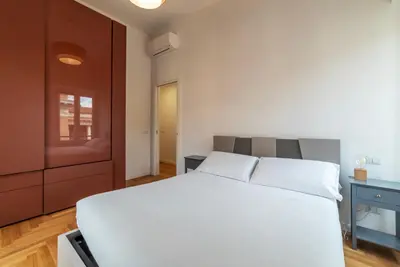 a bedroom with a white bed and a desk at Bartolomeo de' Vaccinari - FromHometoRome in Rome