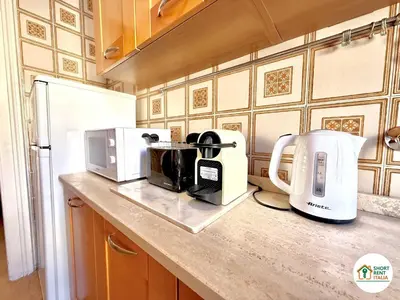 a kitchen counter with a coffee maker and a microwave at Santa Maria Maggiore - Vittorio Emanuele House in Rome