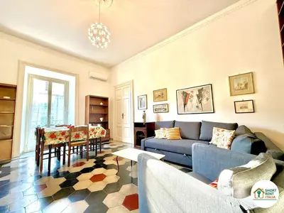 a living room with a blue couch and a table at Santa Maria Maggiore - Vittorio Emanuele House in Rome