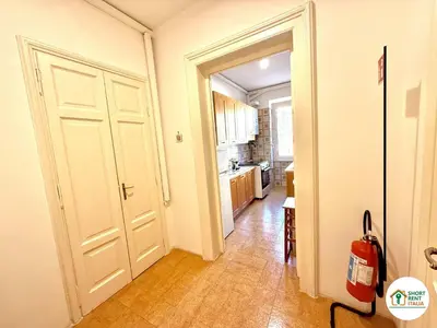 a hallway with a white door and a kitchen at Santa Maria Maggiore - Vittorio Emanuele House in Rome