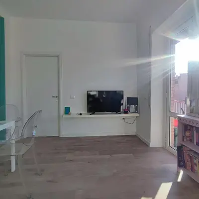 a white living room with a tv on a wall at La mia casetta a Roma Montesacro in Rome