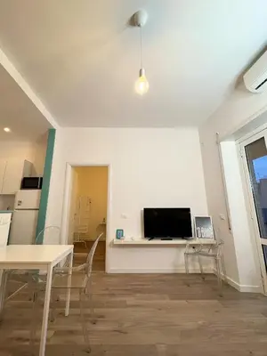 a living room with a table and a tv on a wall at La mia casetta a Roma Montesacro in Rome