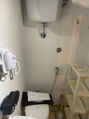a bathroom with a toilet and a hair dryer on a shelf at La casetta ai fori imperiali in Rome