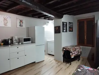 a kitchen with white cabinets and a table in a room at La casetta ai fori imperiali in Rome