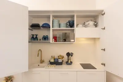 a kitchen with white cabinets and a sink at Carpe Diem by Rental in Rome in Rome