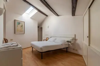 a white bedroom with a bed and a window at Manara 29 - FromHometoRome in Rome