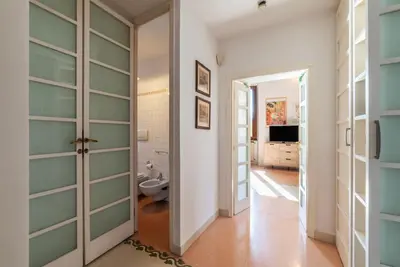 a hallway with glass doors and a bathroom with a toilet at Manara 29 - FromHometoRome in Rome